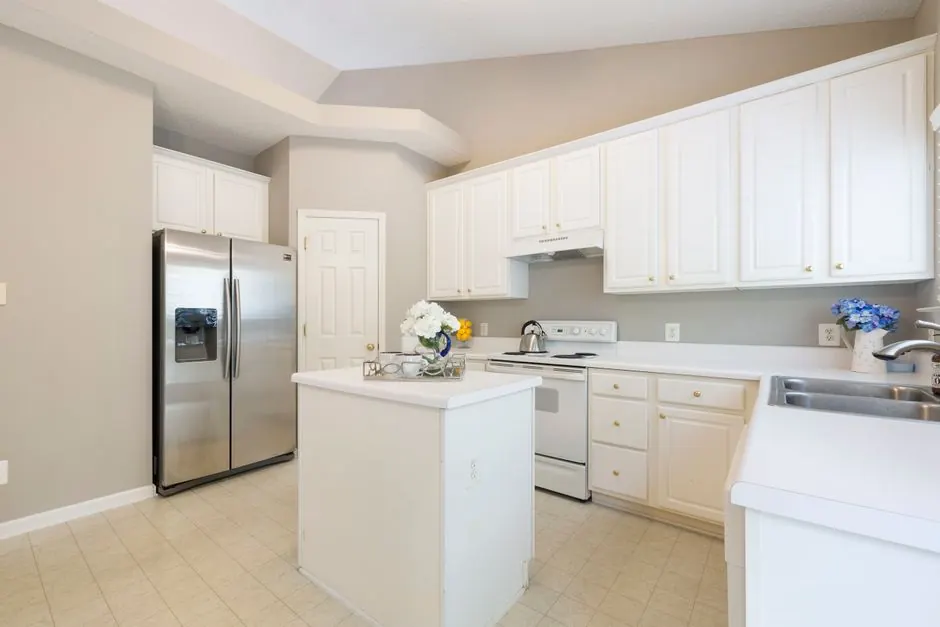 Modern kitchen with white cabinets and a stainless steel refrigerator