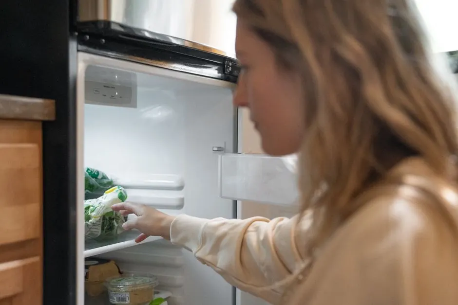 Woman taking vegetables out of a refrigerator