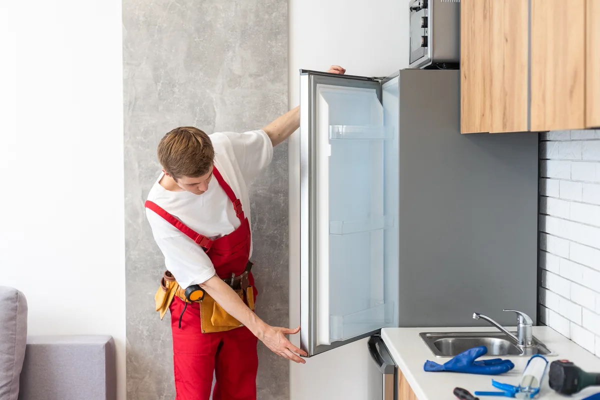 Technician checking a refrigerator door seal